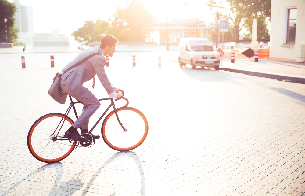 Businessman riding bicycle to work in town