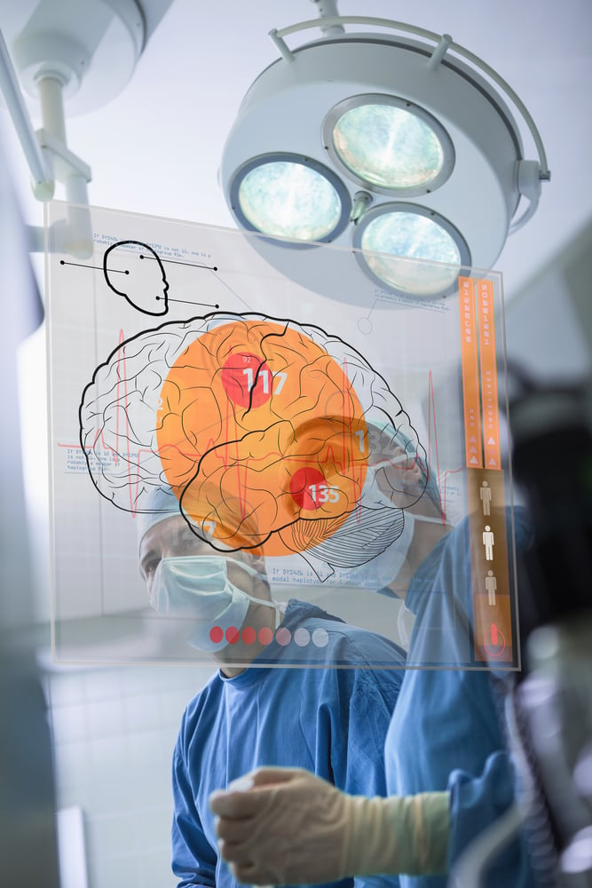 Two surgeons looking at the brain on an interface in surgery